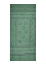 Doubles as a beach throw. The Kale Om Sarong from The Forest Set, sage green, photographed against white.