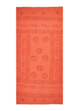 Cotton blend, soft from the first wash. The Papaya Om Sarong from The Citrus Set, coral, shown flat.